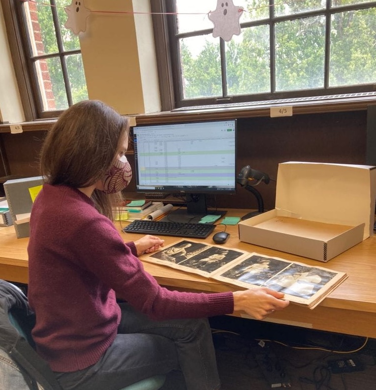 Photo of Leslie reviewing archival photo albums